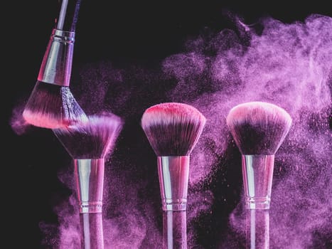 Cosmetics brush and explosion colorful makeup powder background - beauty make-up product and mineral cosmetic concept