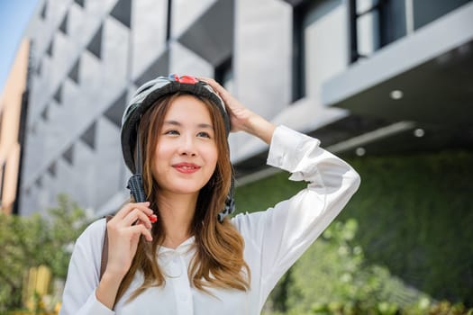 Close up smiling woman wearing helmet exercise outdoors with bicycle on street