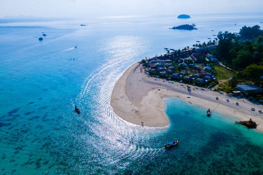 drone view at the beach of Koh Kradan island in Thailand couple men and woman walking on the beach