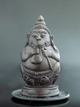 Figurine of Phali, (The Unbeatable Money King) Sculpture Statue on Dark Background.