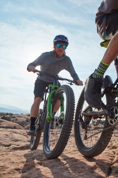 Doing what outdoor lovers do best. two athletic men mountain biking through the wilderness.