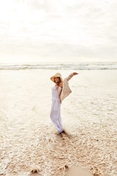 Stress-free and totally loving it. a young woman standing with her arms outstretched at the beach.