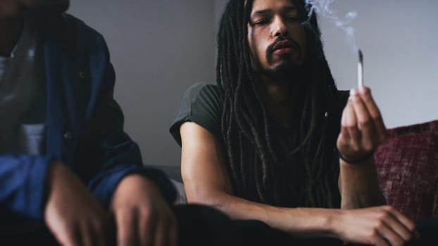 What strain is this. two young men smoking a marijuana joint at home.