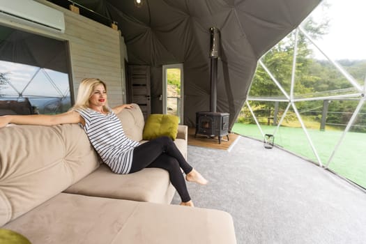 a woman enjoys solitude inside of a transparent bubble hotel.