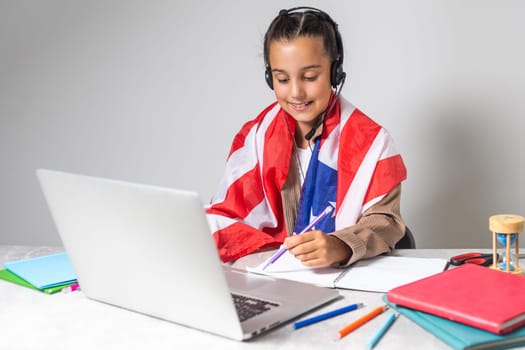 little girl studying with laptop and usa flag