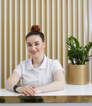 Female receptionist at reception desk in a modern office lobby