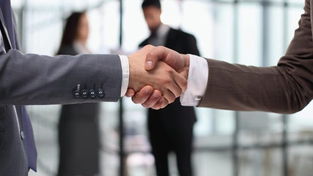 Close-up of business partners handshaking after successful agree