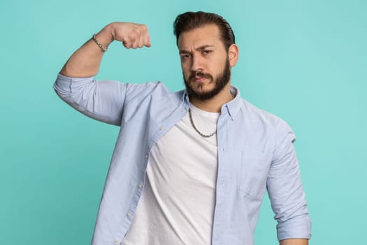 Fit sporty lebanese man showing biceps and looking confident, feeling power strength success win