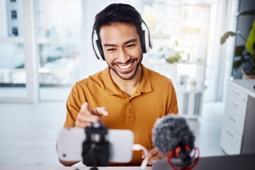 Podcast, pointing and live streaming with a man influencer recording broadcast content in his home office. Internet, streamer and subscription with a male freelancer or creator working in his studio