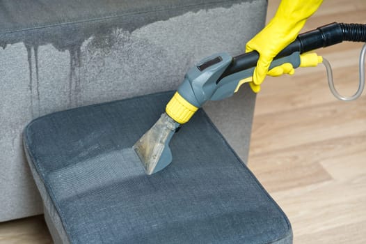Sofa chemical cleaning with professionally extraction method. Wet textile sofa cleaning