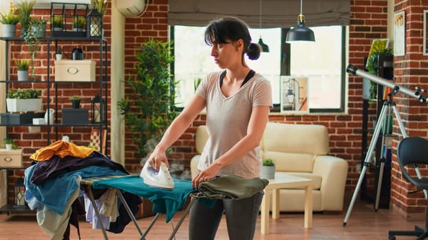 Frustrated woman ironing clothes and being angry at husband
