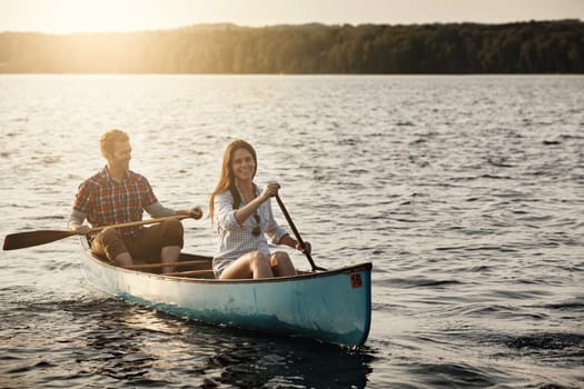 Row your boat and find happiness. a young couple rowing a boat out on the lake.
