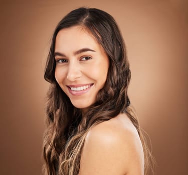 Beauty, portrait and woman in studio for hair, treatment and cosmetics against a brown background. Haircare, face and girl smile for natural, curly or wavy, texture or keratin, textures and confident