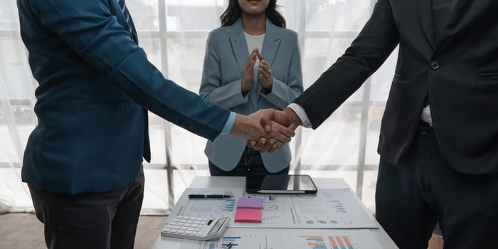 Business people shaking hands finishing up meeting or negotiation in office. Business handshake and partnership concepts