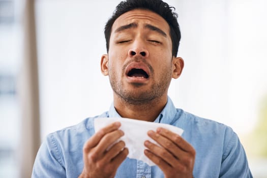 Sick, sneeze and man with a tissue, allergies and sickness with symptoms, cold and illness. Male model, person and guy with congested with sinuses, toilet paper for nose and fever with health issue