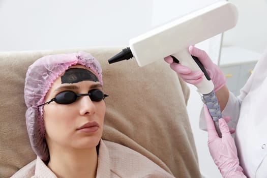 Woman getting carbon peeling in beauty salon