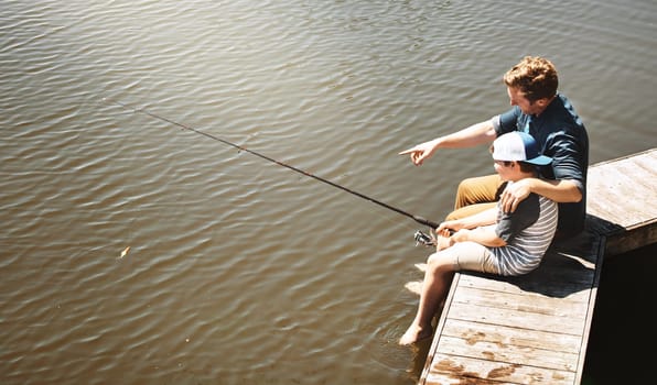 Look, somethings coming closer to the fishing rod...a father and his little son fishing together.