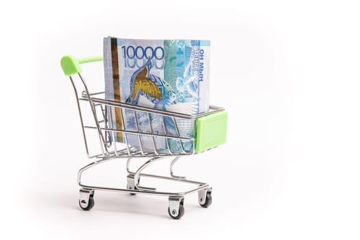 10000 banknotes of Kazakhstani tenge in a shopping cart isolated on a white background
