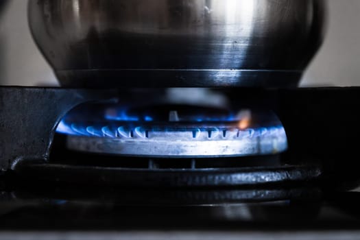 Flame from natural gas on a stove burner with a cooking pot