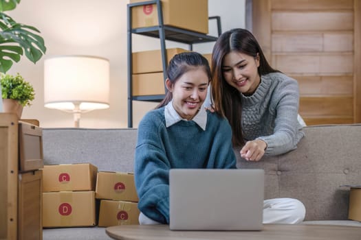 Two Asian Young business woman on sofa at home. startup sme small business entrepreneur SME distribution warehouse with parcel mail box. SME Online marketing and product packaging and delivery service