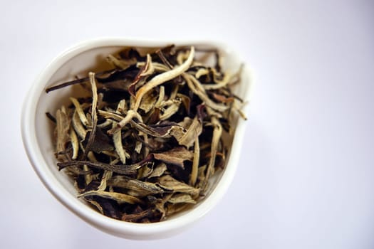 Dry Chinese white tea in a porcelain bowl