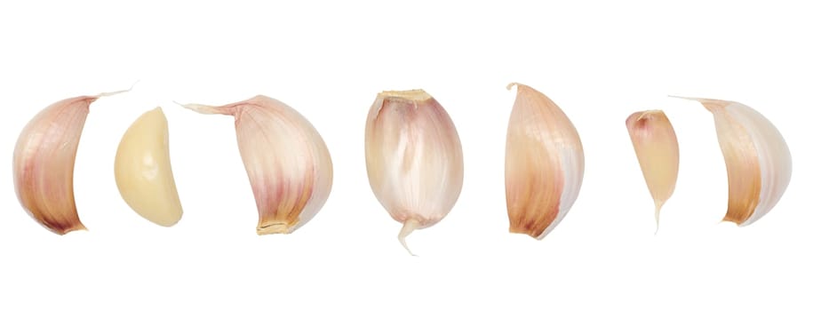 Peeled and unpeeled garlic on a white isolated background
