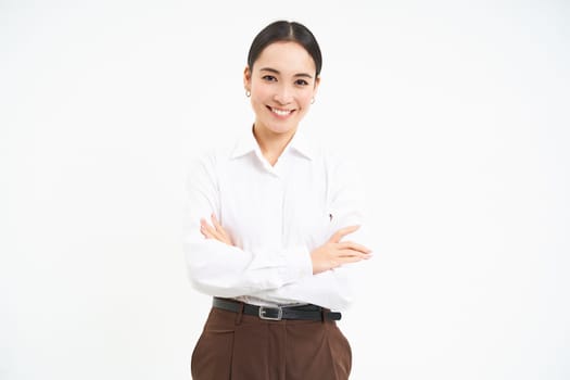 Confident female manager, asian saleswoman holds arms crossed with professional look, white background