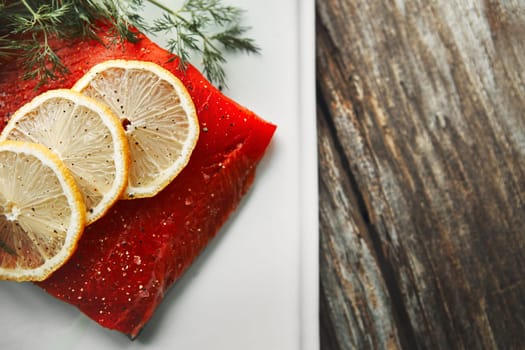 Putting protein in the spotlight. a raw piece of meat garnished with slices of lemon.