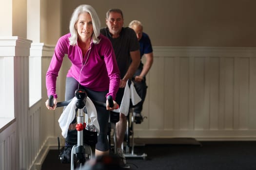 Fitness is great for ageing and for the mind. a group of seniors having a spinning class at the gym