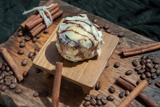 Chocobon (Soft chocolate bun) topped with rich cream cheese frosting and Cinnamon with Coffee beans on wooden.