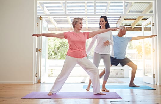 Youre doing great. Full length shot of a female yoga instructor working with a senior couple.