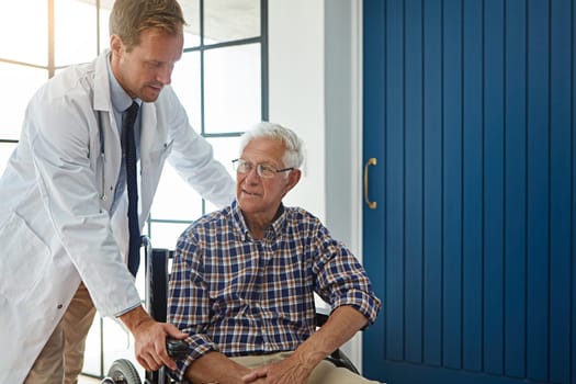 Where to. a male doctor talking to a senior patient in the retirement home.