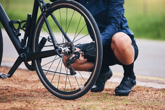 Person, bike and wheel repair outdoor for training, triathlon sports and transportation problem. Closeup of athlete, bicycle and check tire chain for travel safety, cycling maintenance and fixing hub.