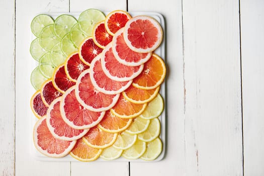 Get your colourful boost of vitamin C. a variety of citrus fruits cut into slices on a plate.