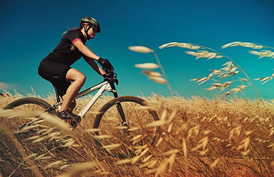 Go out on your own adventure. an adventurous woman out cycling in the countryside.