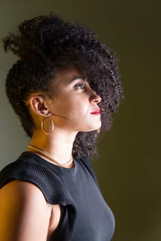 Beautiful young woman in profile wearing black clothing, with hair in her face. 