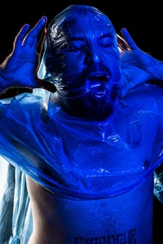 Man with plastic bag over his head, suffocated. Studio shot with blue filter. 