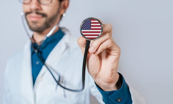 USA flag on stethoscope. Doctor holding stethoscope with USA flag, Doctor showing stethoscope with usa flag