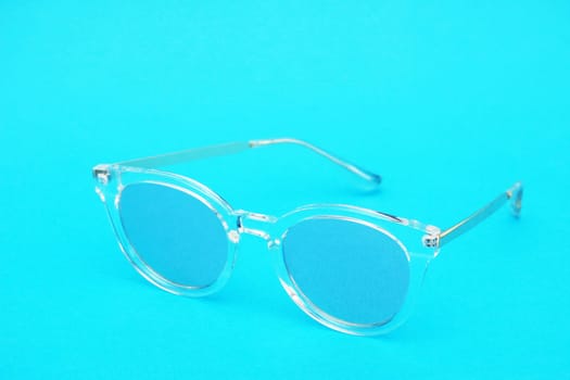 Classic blue sunglasses on a blue background.