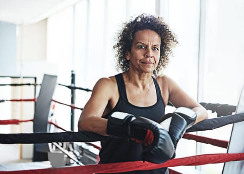 Shes a boxing legend. a mature woman training in a boxing ring.