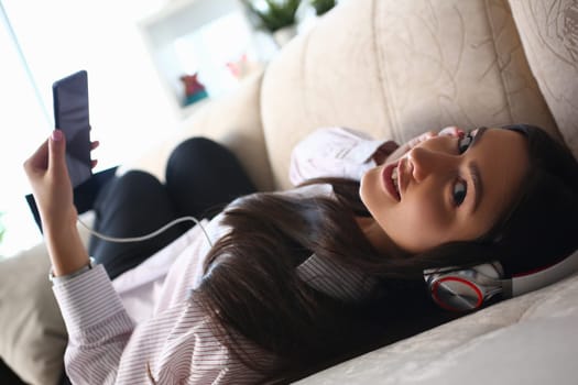 Relaxed woman listening to music on headphones at home