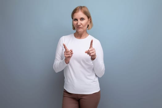 blond charming middle-aged woman in a white sweater demonstrates super class