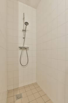 a white shower in a white tiled bathroom