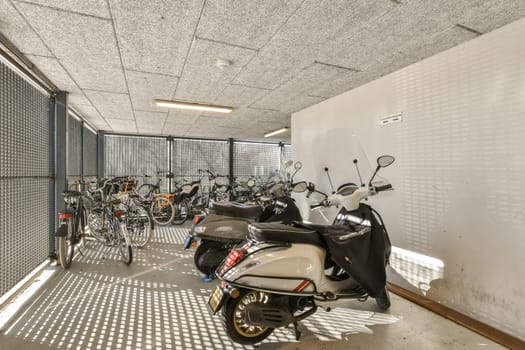a motor scooter parked in a garage with bikes