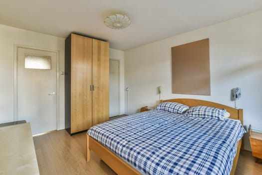 a bedroom with a bed and a wooden wardrobe