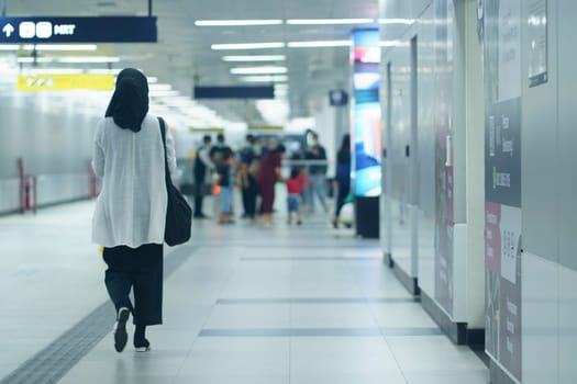 A hijab woman walking to the entry gate at MRT Jakarta Station, Indonesia. April 20, 2023.