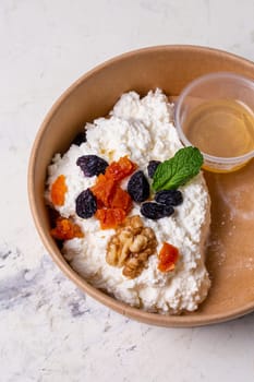 Breakfast cottage cheese with dried fruits top view. tomorrow in craft dishes