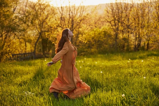 a joyful woman runs through a green field during the sunset enjoying a warm summer day and nature. Horizontal photography in nature