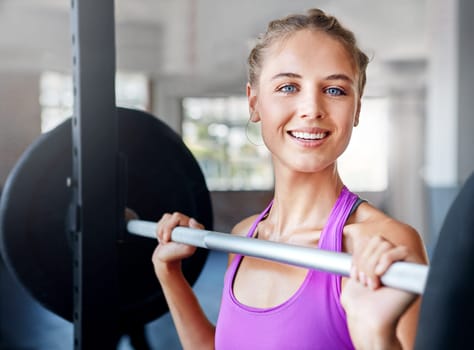 Youre stronger than you think. a young woman working out with weights at the gym.