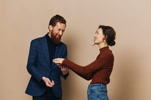 Man and woman couple in a relationship smile and interaction on a beige background in a real relationship between people